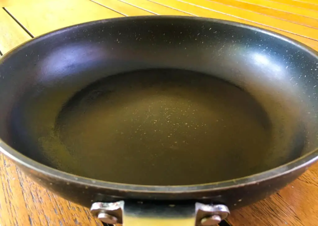 Ceramic non stick pan on top of a wooden table.