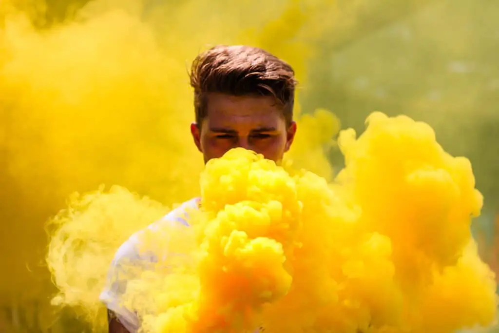 Man shrouded in a bright yellow smoke.