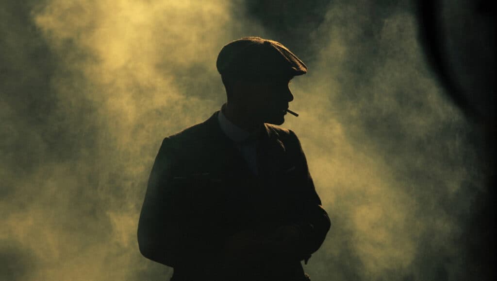 1920's gangster dressed up with a hat, in a misty fog.
