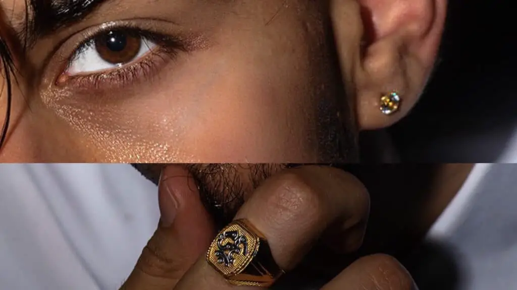 Close up of stylish man wearing ring and earrings.