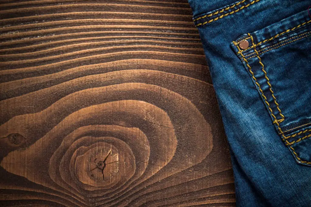 Jeans laying atop wooden table.
