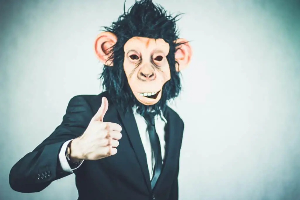 Man wearing monkey mask in suit. 